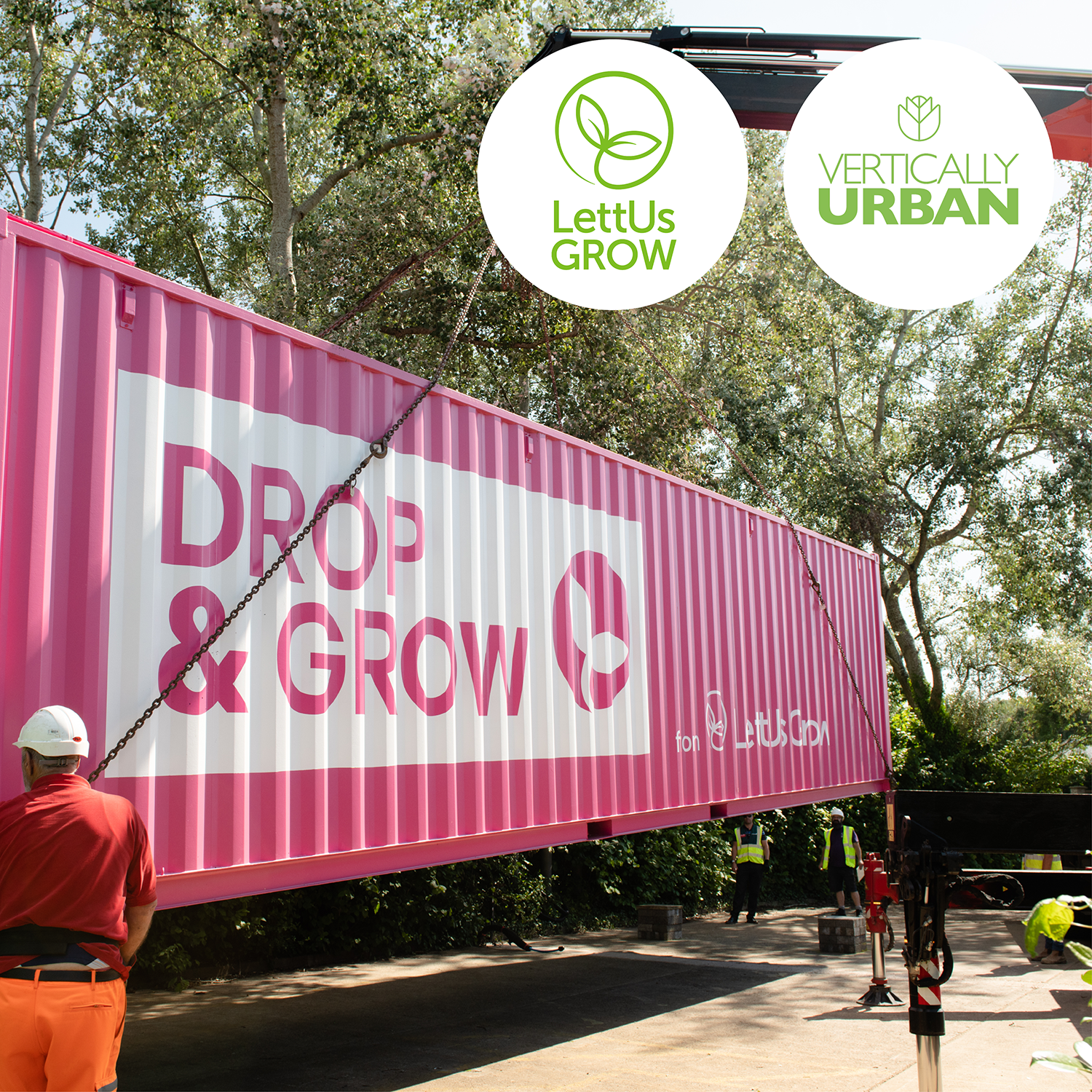 A bright pink LettUs Grow DROP & GROW container farm is lowered into position